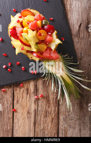 Ananas farci aux fruits exotiques frais sur la table. vertical Vue de dessus Banque D'Images