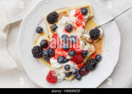 Gaufres aux bleuets, framboises, crème fouettée, sauce aux petits fruits et sirop d'érable Banque D'Images