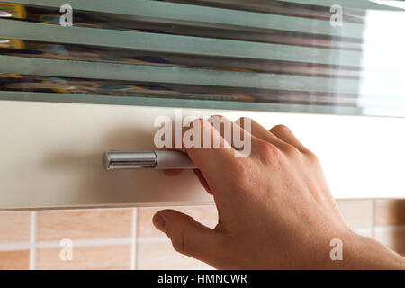 Mans part ouvrir les portes d'armoires de cuisine, Close up Banque D'Images