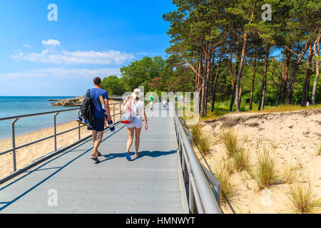 HEL, LA MER BALTIQUE - JUN 22, 2016 : couple de touristes marcher sur le long de la promenade côtière de la plage Hôtel ville sur la côte de la mer Baltique, la Pologne. Hôtel Peninsula est endroit populaire pour les vacances d'été. Banque D'Images