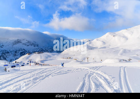 Vue sur le télésiège et les pistes de ski dans la station de ski Obertauern sur journée d'hiver ensoleillée avec de beaux nuages, Autriche Banque D'Images