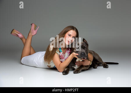 Belle fille avec Stafford Terrier gris Banque D'Images