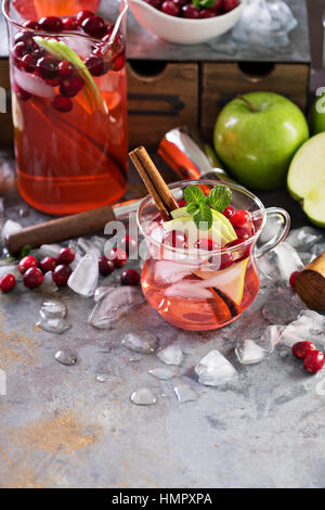 Cocktail d'hiver avec de la glace, les pommes et canneberges dans des tasses en verre Banque D'Images