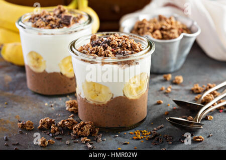 Chia chocolat au lait parfait glacé à la banane, du yaourt et granola Banque D'Images