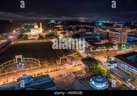 Vue sur le centre-ville de Bandar en traversant Taman Haji Sir Muda Omar Ali Saifuddien Park (C gauche) avec la mosquée Omar Ali Saifuddien (en haut à gauche) et le ministère de l'intérieur (au centre à droite) éclairé en début de soirée sur Jalan McArthur, Bandar Seri Begawan, Darussalam, Brunei. © Time-snapshots Banque D'Images