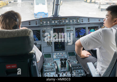 Le pilote et le co-pilote d'un vol de Royal Brunei Airlines discutent de leur départ dans le poste de pilotage de l'Airbus A320 alors qu'ils se préparent pour leur vol vers Singapour à l'aéroport international Bandar de Darussalam, Brunei. © Time-snapshots Banque D'Images