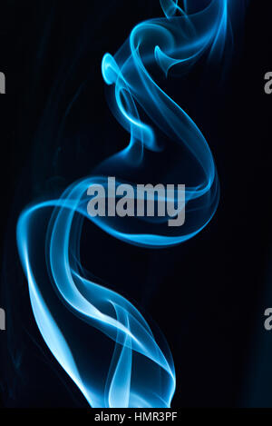 Close up de lignes élégantes de la fumée bleue sur fond noir Banque D'Images