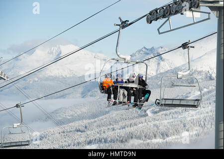 Les skieurs ride d'un télésiège au sommet de Whistler Mountain pour une journée ensoleillée en hiver. Whistler, BC, Canada. Banque D'Images