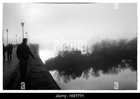 Merida, Estrémadure, Espagne. Misty coucher de soleil sur le pont romain. Banque D'Images