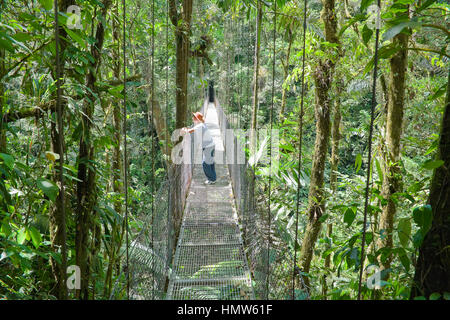 Homme debout sur le pont suspendu dans la forêt tropicale, la Fortuna, Costa Rica Banque D'Images