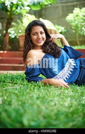 Jeune latina girl laying on Green grass Banque D'Images