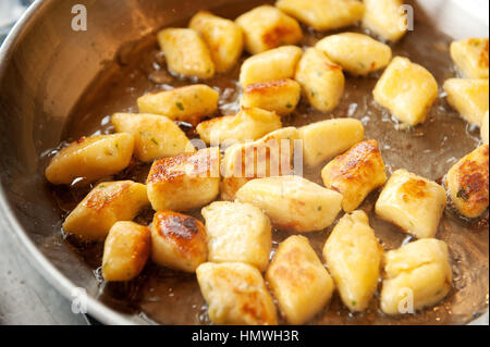 Gnocchi boulettes frire dans la graisse de canard dans une poêle à frire. Gnocchi sont différents d'épaisseur, boulettes de pâte souple qui peut être faite de la semoule, le blé ordinaire Banque D'Images