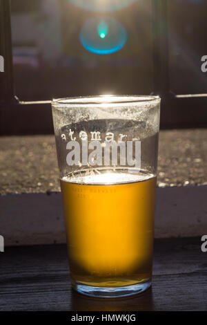 Une pinte de bière avec de l'or de Batemans du soleil brillant à travers elle Banque D'Images