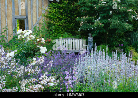 Jardins du pays d'Auge, ici jardin appelé 'le repos du jardinier' avec une grange et 4 carrés de boîtes et de vivaces Banque D'Images