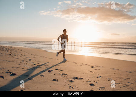 Jeune homme de la formation sur la plage le matin. Jeune homme sur matin couru à l'extérieur. Banque D'Images
