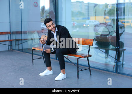 Entrepreneur smiling man met sur tablette utilise des lunettes et regarde. Young handsome businessman musulmans arabes dans le centre d'affaires de porter habillé en b Banque D'Images