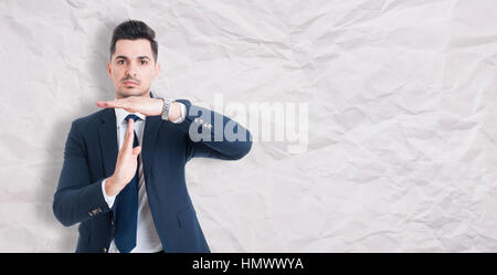 Serious businessman showing time out signe avec les mains aussi briser concept isolé sur fond de papier froissé avec copyspace Banque D'Images