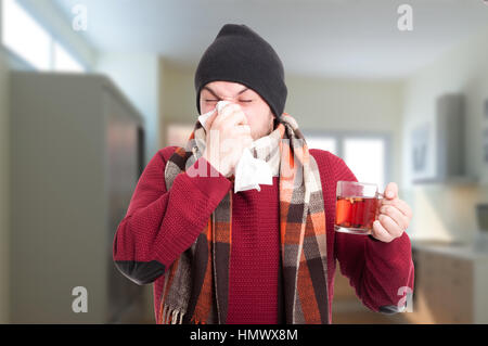 Mauvais homme tenant un plateau tasse et soufflant son nez dans un mouchoir comme concept de la rhinite Banque D'Images