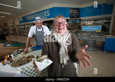 La clientèle rédaction Col Juin tente une huître pour la première fois, établi par des spécialistes de la mer Morrisons Andrew Speight au magasin de l'entreprise à Bradford comme la chaîne de supermarchés réduit le coût d'huîtres, un aphrodisiaque, à 25p pour la Saint-Valentin. Banque D'Images