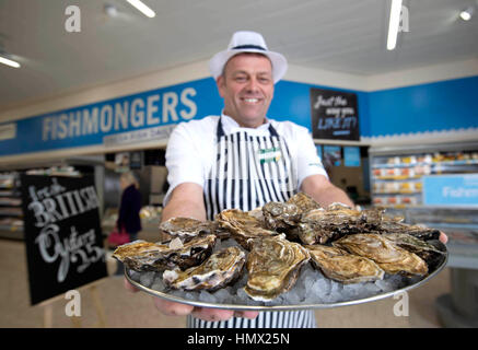 EDITORIAL N'utilisez que des fruits de mer spécialiste Morrisons Andrew Speight prépare les huîtres pour les clients à Morrisons dans Bradford comme la chaîne de supermarchés réduit le coût d'huîtres, un aphrodisiaque, à 25p pour la Saint-Valentin. Banque D'Images