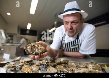 EDITORIAL N'utilisez que des fruits de mer spécialiste Morrisons Andrew Speight prépare les huîtres pour les clients à Morrisons dans Bradford comme la chaîne de supermarchés réduit le coût d'huîtres, un aphrodisiaque, à 25p pour la Saint-Valentin. Banque D'Images