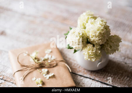 Lilas blanc bouquet dans un vase et d'aujourd'hui mis sur la table en bois. Banque D'Images