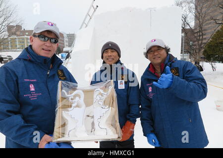 Sapporo, Japon. Feb 6, 2017. L'Hawaians Dale Radomski, Charlie Matsuda et Norimitsu Wada-Goode au festival de neige à Sapporo, Japon, 6 février 2017. Dale détient sur un modèle d'une sculpture de neige qu'ils vont se tailler un bloc de neige dans l'arrière-plan. Photo : Nicolaysen Lars/apd/Alamy Live News Banque D'Images