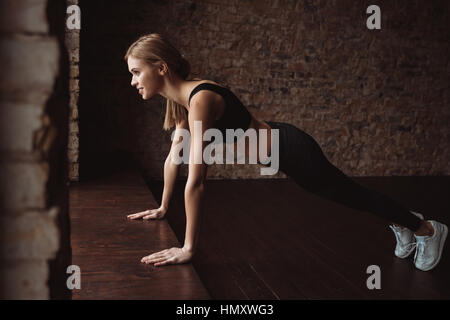 Happy young de la sportive faisant pompes sur le sol Banque D'Images