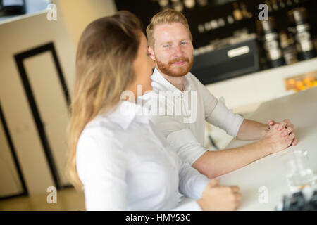 Happy business people habillés formellement flirting in cafe Banque D'Images