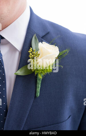 Groom boutineer épinglé sur sa veste de costume de la marine sur son mariage. Banque D'Images