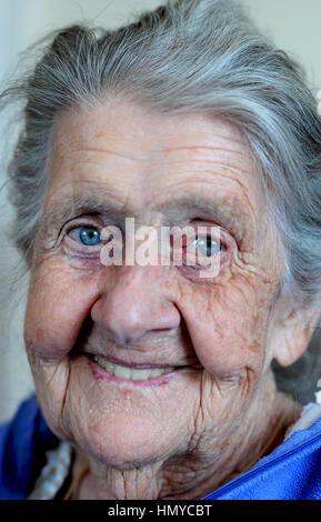 Vieille Femme à la maison, Taunton, Royaume-Uni, 2015. Une femme âgée dans son 80s qui souffrent de pertes de mémoire et la démence, assis dans son salon. Banque D'Images