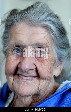 Vieille Femme à la maison, Taunton, Royaume-Uni, 2015. Une femme âgée dans son 80s qui souffrent de pertes de mémoire et la démence, assis dans son salon. Banque D'Images