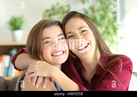 Vue de face d'un portrait de deux sœurs ou amis heureux souriant et posant en vous regardant avec un arrière-plan Banque D'Images