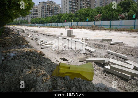 Blocs de bordure étendue sur le sol pendant la circulation sur route en construction, Suzhou Industrial Park, Suzhou, Jiangsu, Chine Banque D'Images