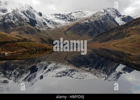 Vue vers l'ouest le long de Llyn Ogwen dans le parc national de Snowdonia dans le Nord du Pays de Galles. Les pics couverts de neige de Snowdonia en arrière-plan. Banque D'Images