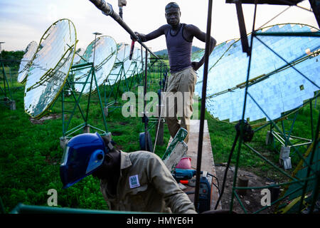 Le BURKINA FASO, Dano, fondation Dreyer, moulin à riz avec four solaire, la vapeur est produite par miroir parabolique pour traiter le paddy, travailleur qualifié travaillant au système de canalisation d'eau / BURKINA FASO, Dano, Stiftung Dreyer, Reismuehle Parabolspiegeln mit Solaranlage mit zur Dampferzeugung fuer Reisverarbeitung, Facharbeiter bei Arbeiten am Wasserrohrsystem Banque D'Images