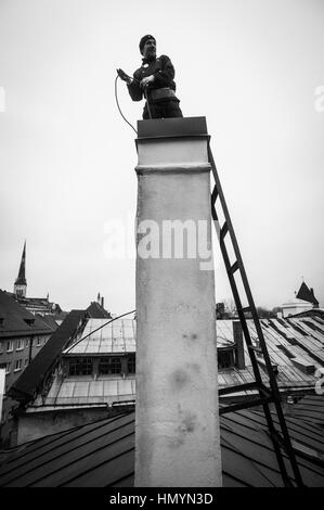 Tallinn, Estonie 22.11.2016. Jurmo (27) travaille sur le dessus d'une cheminée dans la vieille ville historique. Banque D'Images