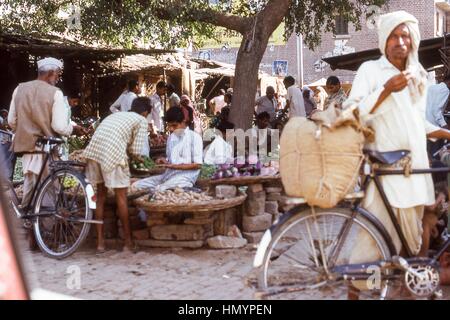 Scène d'Indiens et de garçons shopping dans les étals de marché ombragée dans le Sadar Bazar, Agra, Uttar Pradesh, Inde, novembre 1973. Banque D'Images