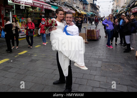 Un marié israélien posant avec sa mariée lors d'une séance de photographie avant mariage à Mahane ou au marché de Machane Yehuda souvent appelé "le Shuk", un marché en plein air à Jérusalem-Ouest, Israël Banque D'Images