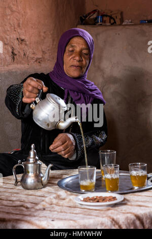 Le Maroc. Berbère amazighe Woman Pouring Tea, Ksar Ait Benhaddou, un site du patrimoine mondial. Banque D'Images