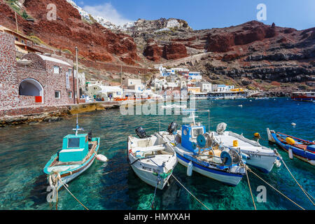 Les bateaux de pêche locaux amarré au pied des falaises à la baie d'Ammoudi, Oia, Santorin, une île grecque de la Méditerranée dans le groupe des Cyclades Banque D'Images