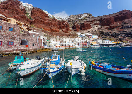 Les bateaux de pêche locaux amarré au pied des falaises à la baie d'Ammoudi, Oia, Santorin, une île grecque de la Méditerranée dans le groupe des Cyclades Banque D'Images