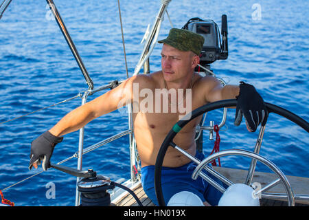 Jeune homme capitaine d'un yacht à voile. Vacances de luxe. Sports extrêmes. Banque D'Images