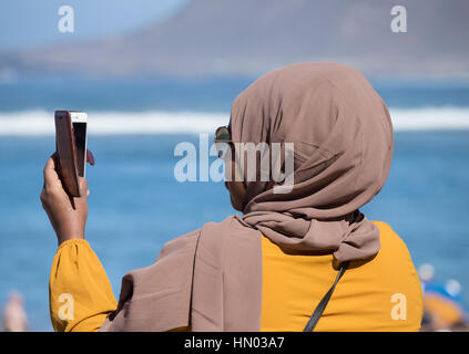 Femme portant le hijab, casquettes porté par les femmes musulmanes, en tenant sur selfies beach en Espagne Banque D'Images