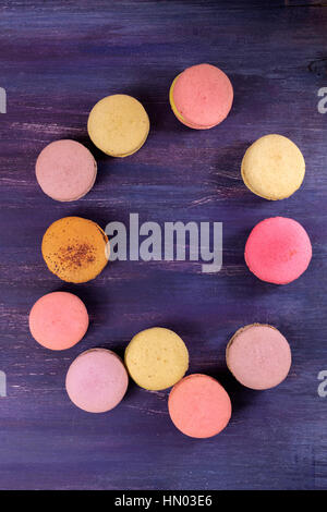 Une photo des différents macarons, tourné à partir de ci-dessus, sur un fond violet vibrant texture, with copy space Banque D'Images