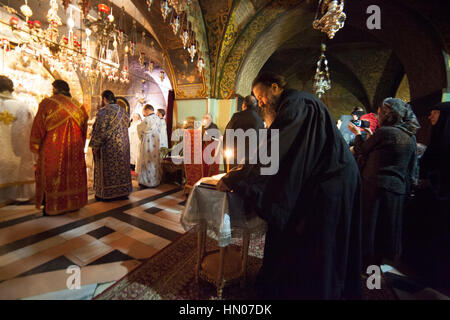 Jérusalem, Israël - 15 novembre 2013 : célébrer la messe des prêtres orthodoxes grecs en face de crucifixion autel dans l'église du Saint-Sépulcre. Tous les privil Banque D'Images