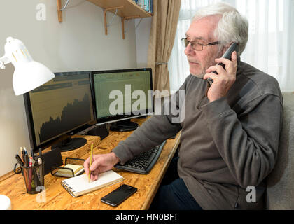 Senior man on phone in office.Le travail à domicile dans un bureau à domicile. Banque D'Images