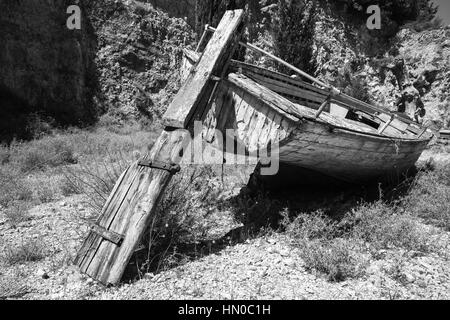 Vieux bateau de pêche en bois sec abandonné se pose sur le sol. Photo en noir et blanc Banque D'Images