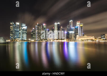 Une réflexion de la gratte-ciel du quartier des affaires de Singapour Marina Bay dans l'horizon de la promenade du bord de mer. Tourné avec une longue exposition à smo Banque D'Images