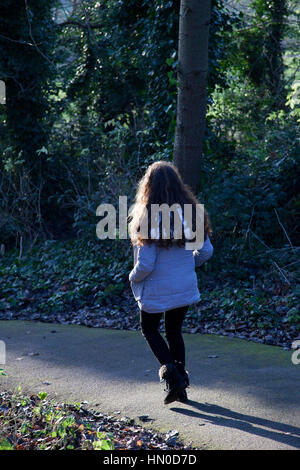 Jeune femme marche dans un parc. Vue arrière. Banque D'Images